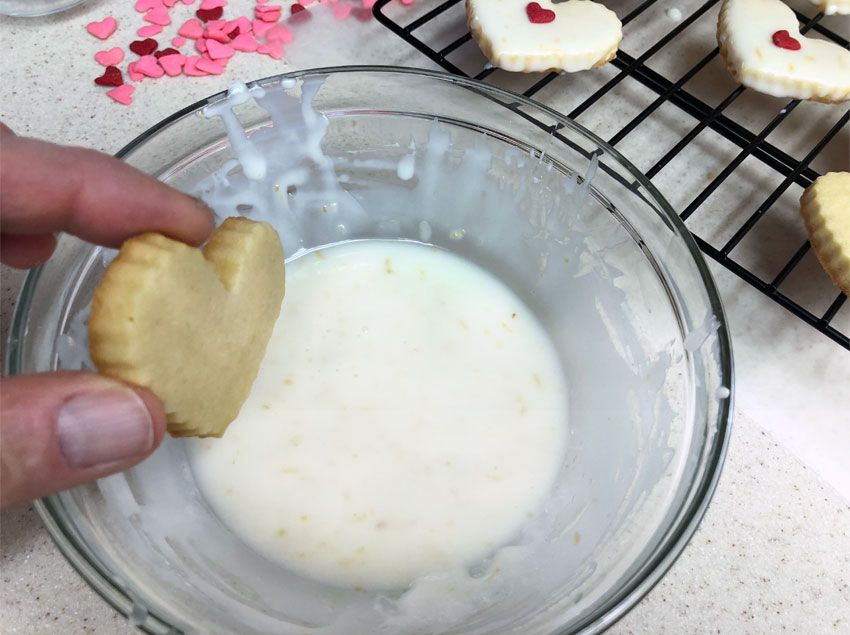 Dipping the cookie into the glaze